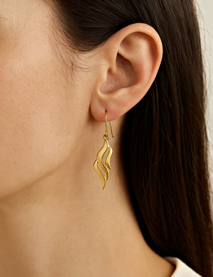 gold dangle earrings wave design on model