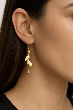 leaf design dangle earrings in gold on model